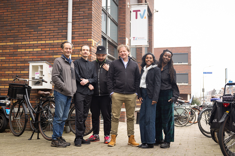 Groepje leden van de cliëntenraad staat voor een gebouw van de Tussenvoorziening.